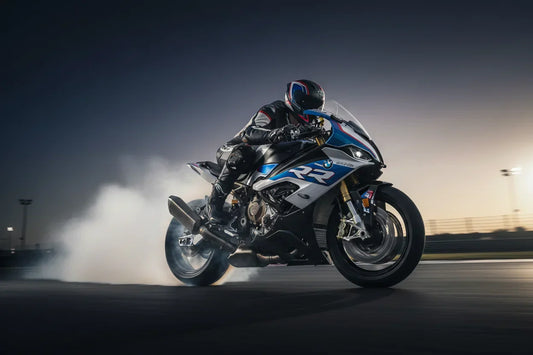 BMW S1000RR blanche et bleue sur circuit, sportive allemande légendaire, angle bas dramatique